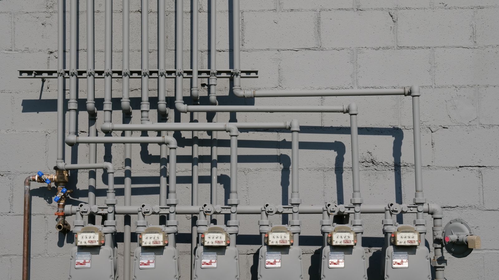 Gaszähler und Rohrleitungen an einer Hauswand