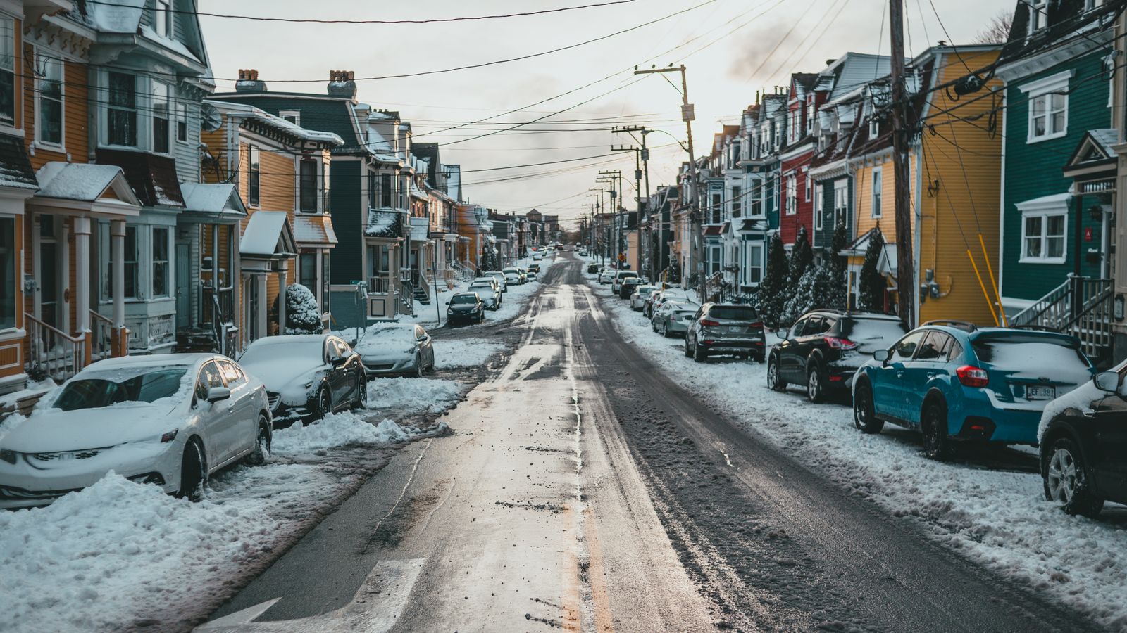 Verschneite Wohnstraße mit Einfamilienhäusern im Winter